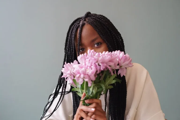 Woman smelling pink flowers, capturing the sensory pleasures and good things about ADHD.
