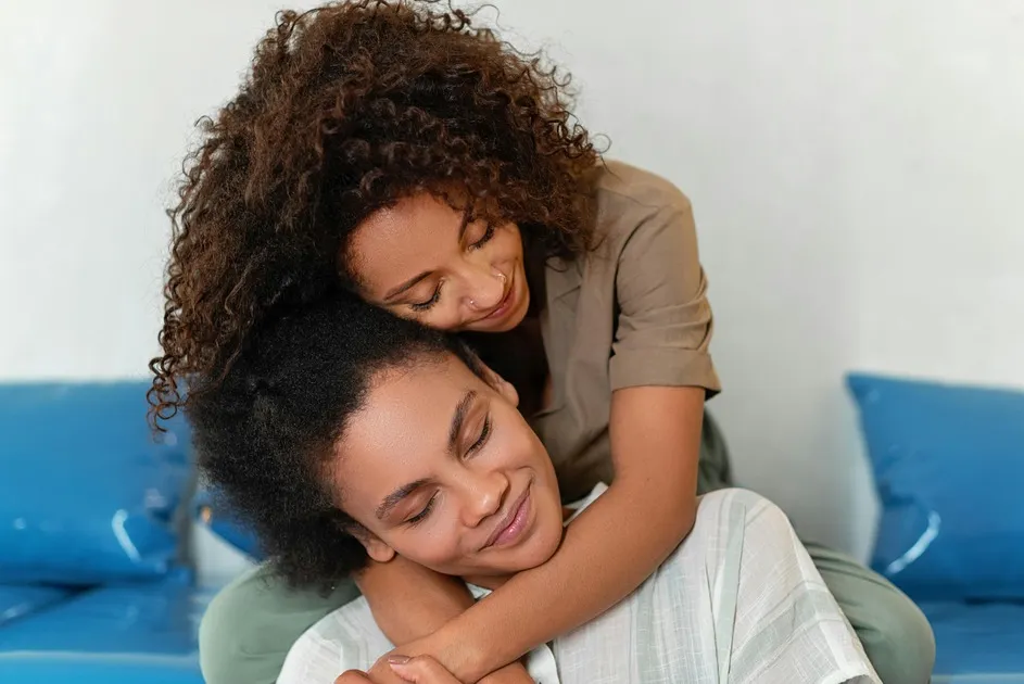 Woman hugging another woman from behind