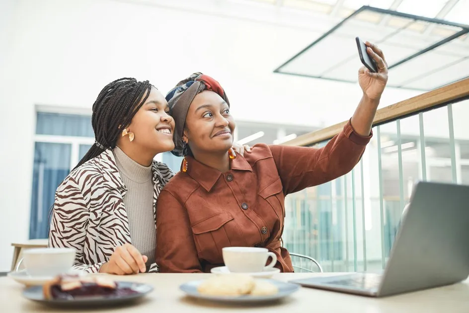 Two women taking a selfie at a cafe