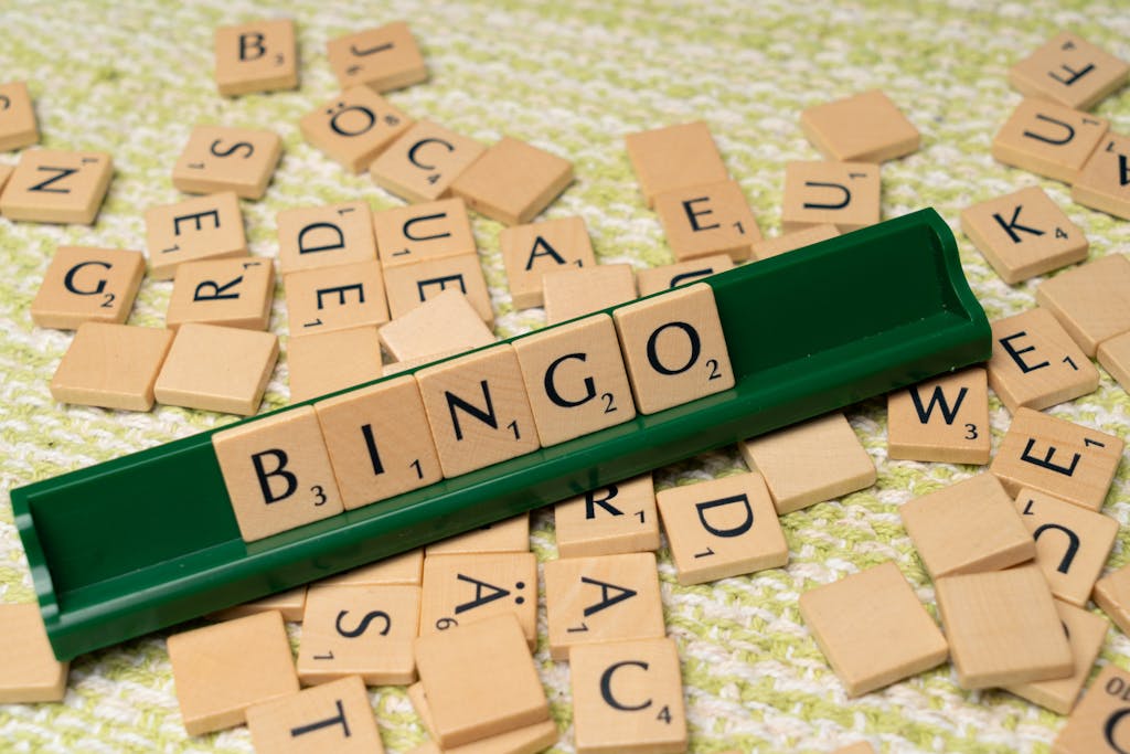 Wooden Scrabble tiles arranged to spell 'BINGO' on a green rack representing ADHD Bingo.